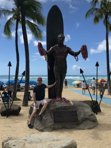 Matt next to a statue of Duke Hahanamoku at Waikiki Beach Hawaii