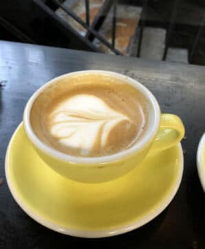 A yellow cup of flat white coffee